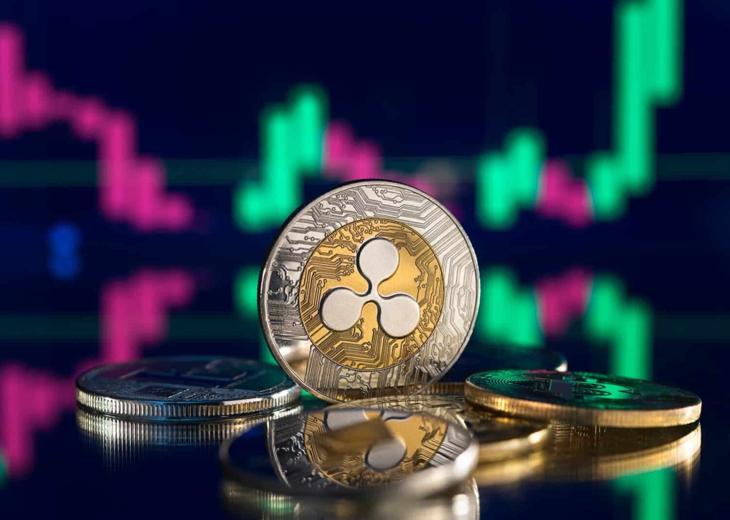 Bitcoin and cryptocurrency investing concept. Cryptocurrency golden coin with gold ripple symbol. Rise and fall charts of alt coins.