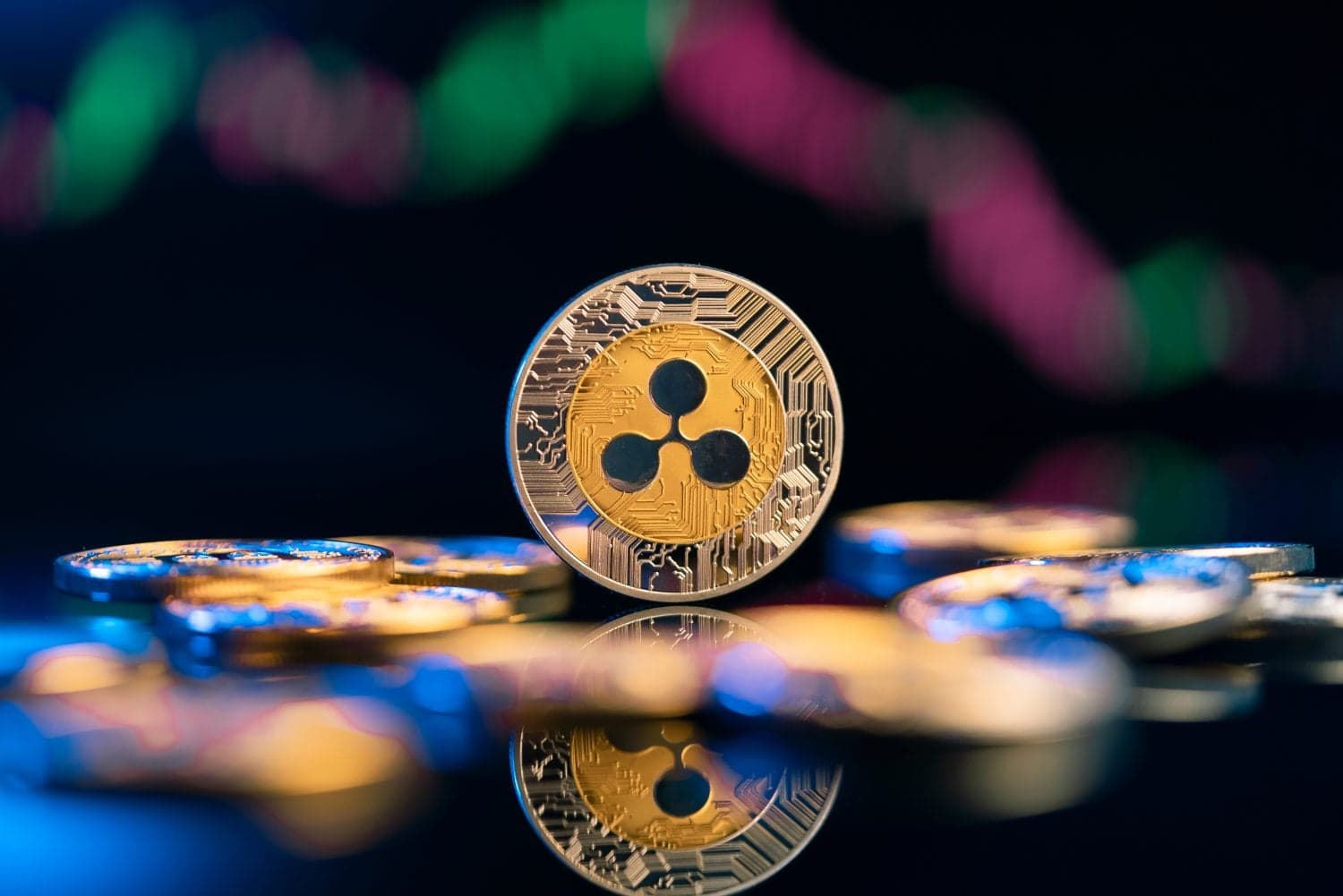 Ripple XRP cryptocurreny coin in front of colorful abstract background with candlestick chart diagram
